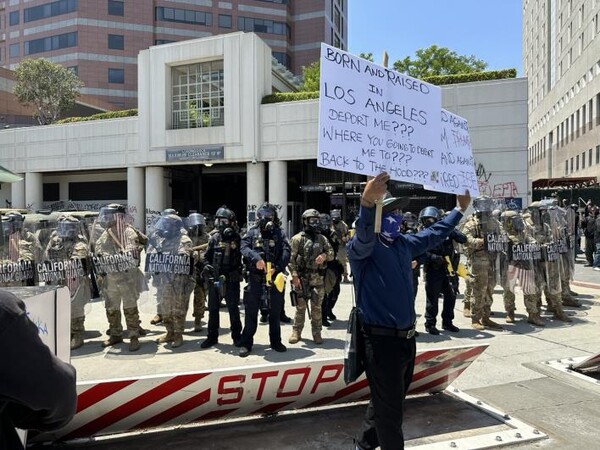 8일(현지시간) 미국 로스앤젤레스(LA) 도심 연방 구금시설인 '메트로폴리탄 디텐션 센터'(MDC) 앞에서 주방위군이 시위대와 대치하고 있다. ⓒ위클리서울/연합뉴스